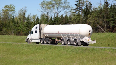 White truck with tanker trailer in country