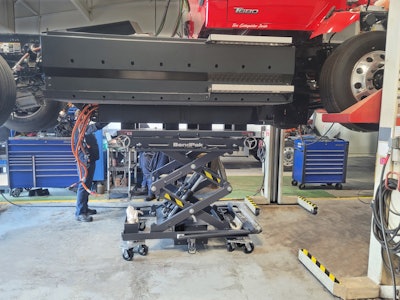 A lift holding up part of a T680 truck.