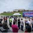 A crowd of people in front of Felling Trailers and the AEM Manufacturing Express bus.