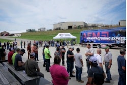 A crowd of people in front of Felling Trailers and the AEM Manufacturing Express bus.