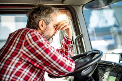 A frustrated driver behind the wheel of a truck