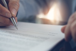 Man with pen looking at contract