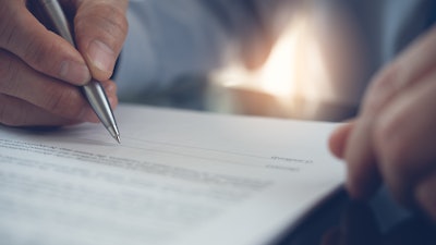 Man with pen looking at contract