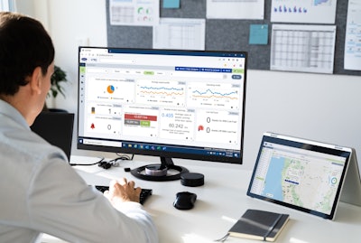 A man working at a computer screen displaying Lynx Fleet, Carrier Transicold's telematics platform.