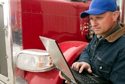 Man holding laptop while standing by truck