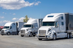 Three white trucks in a lot