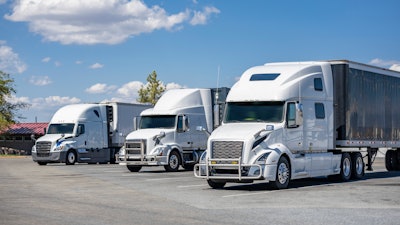 Three white trucks in a lot