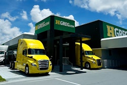 Two trucks outside of an HGreg dealership