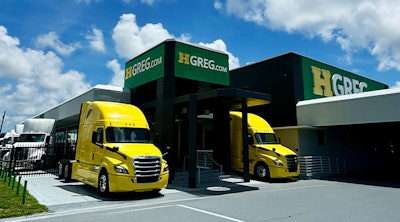 Two trucks outside of an HGreg dealership