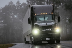 Mack truck on highway with headlights on