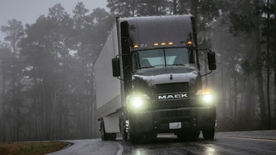 Mack truck on highway with headlights on