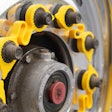 A yellow LUG LINX system sits on lug nuts on a truck wheel.