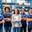 A group of people stand in front of shelves of goods