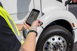 Bridgestone worker using app by a tire