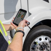 Bridgestone worker using app by a tire