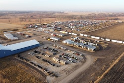 A facility showing trucks parked in rows and large buildings