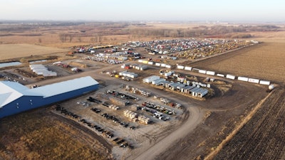A facility showing trucks parked in rows and large buildings