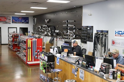 Two men work behind a counter in a parts store