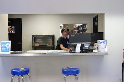 A man works at a computer behind a counter