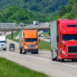 Several trucks on highway with traffic