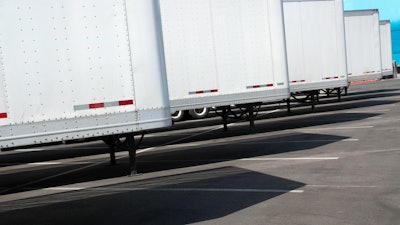 Row of new white trailers in parking lot