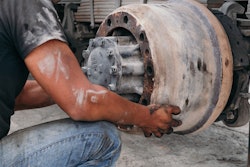 Technician replacing an old brake drum