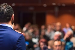 Man speaking to room of employees