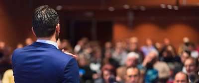 Man speaking to room of employees