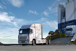 A Hyundai hydrogen fuel cell truck rolls down a ramp in front of a blue sky.