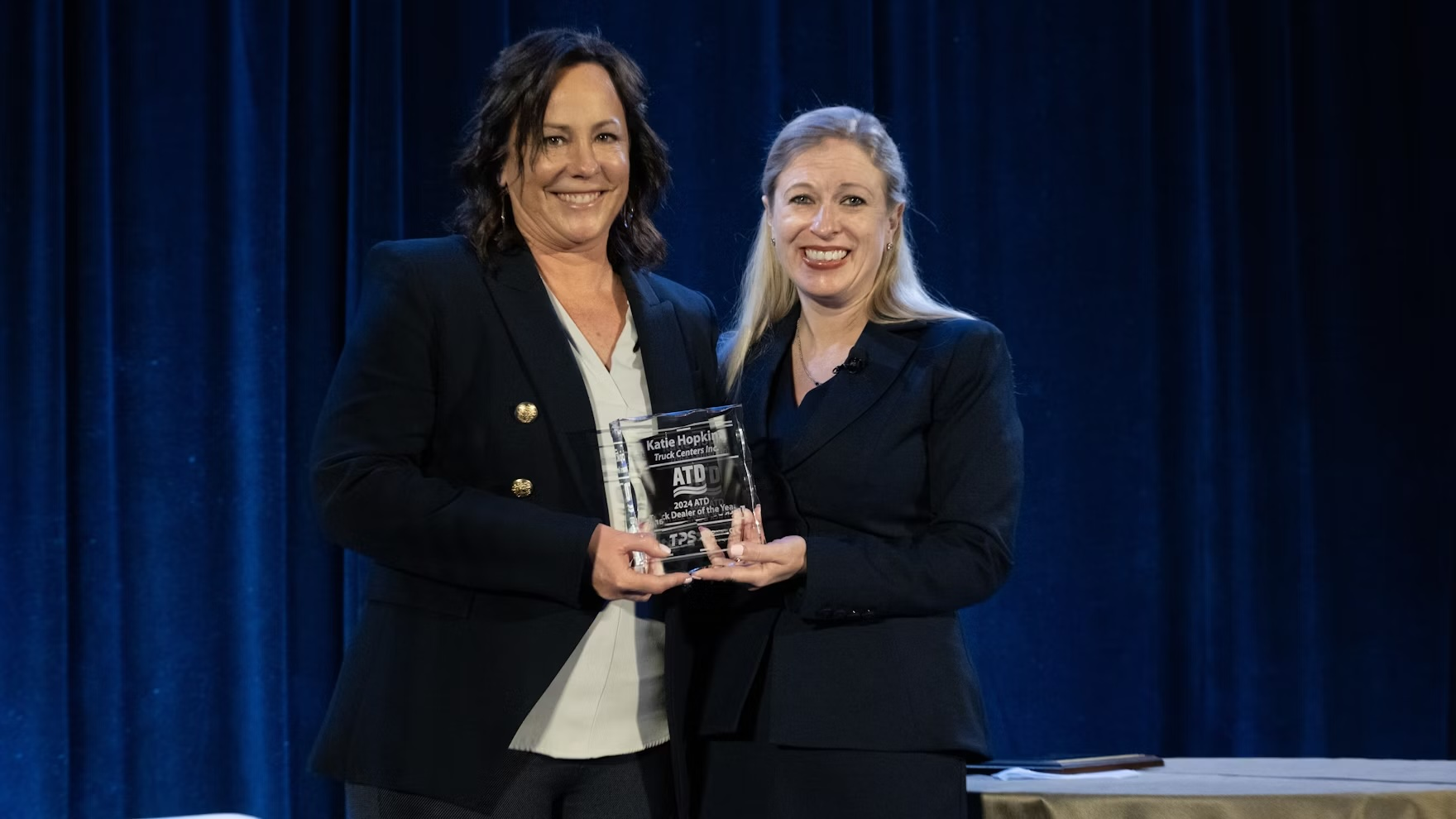 Two women holding an ATD award