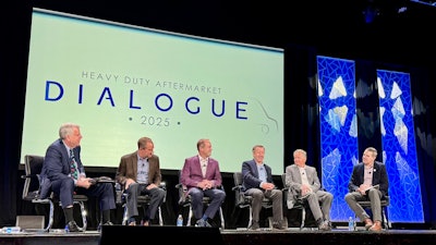 A group of people on a stage with a screen that says Heavy Duty Aftermarket Dialogue 2025