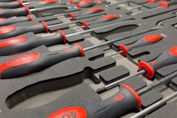 A row of screwdrivers sitting in foam inserts.