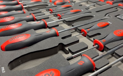 A row of screwdrivers sitting in foam inserts.