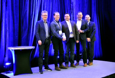 A group of men on a stage with an award.