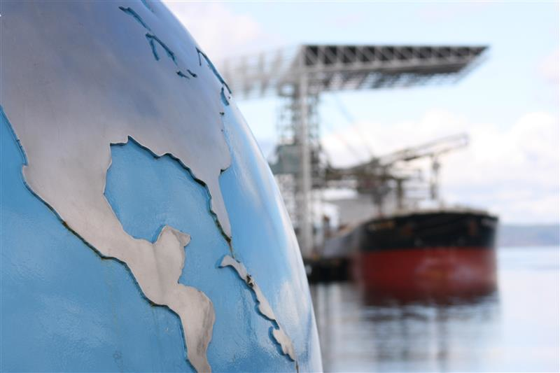 A globe with a ship being unloaded in the background