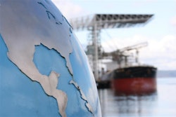A globe with a ship being unloaded in the background