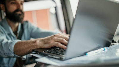 Man in truck using laptop