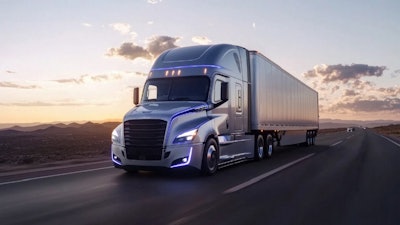 A Freightliner truck traveling on the highway at dusk.