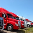 Semi trucks in grass field for sale