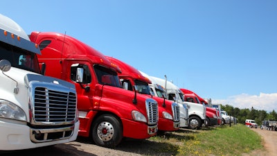 Semi trucks in grass field for sale