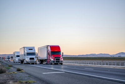 A line of trucks driving on the highway