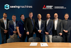 A group of men with the Seeing Machines and Mitsubishi Electric logo in the background