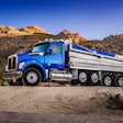A blue Kenworth dump truck with the performance hood