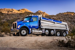 A blue Kenworth dump truck with the performance hood