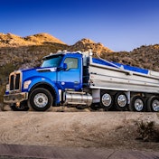 A blue Kenworth dump truck with the performance hood