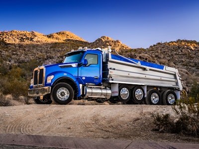 A blue Kenworth dump truck with the performance hood