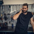 A man on the phone in a mechanic shop