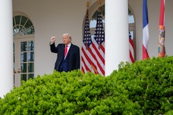 President Donald Trump raises his fist as he walks into the Rose Garden on April 2