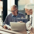 Two Men In Meeting With Computer