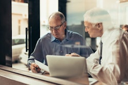 Two Men In Meeting With Computer
